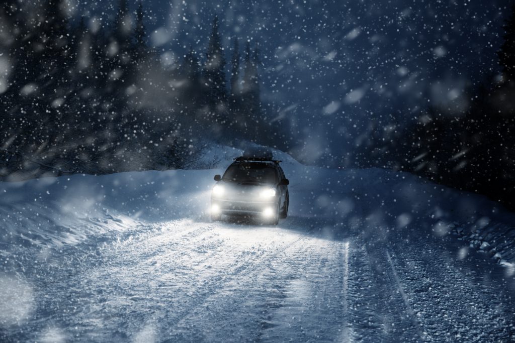 Car lights in winter forest